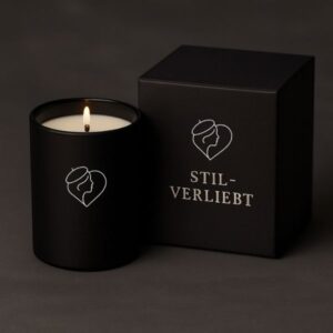 Schwarzes, elegantes Glas mit weißem Stil-verliebt Logo und edler weißer Duftkerze, daneben die schwarze Verpackung mit Stil-verliebt Logo